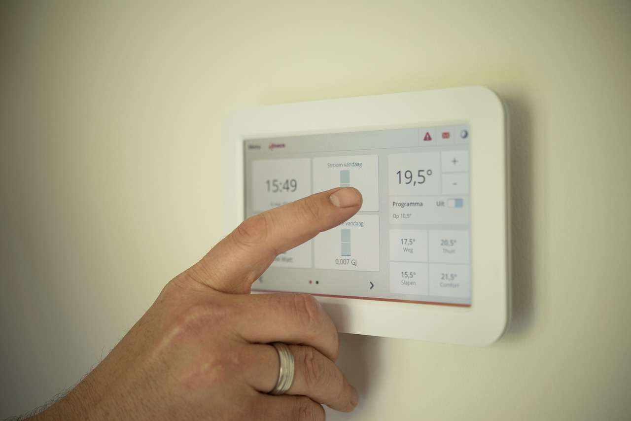 Man bestuurt slimme thermostaat met stemcommando. Man bestuurt slimme thermostaat met stemcommando.