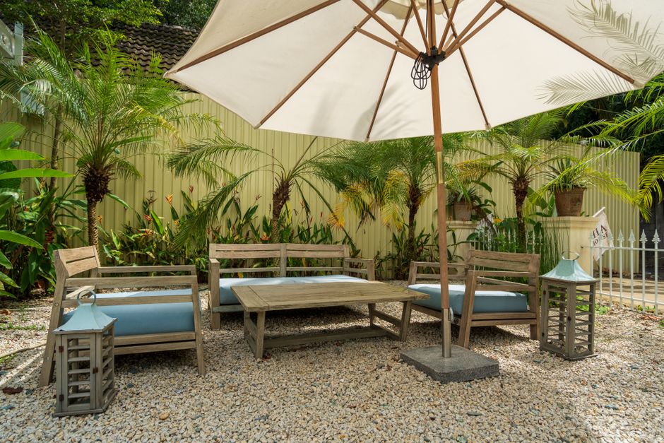 Comfortabele ligstoel onder een grote parasol.