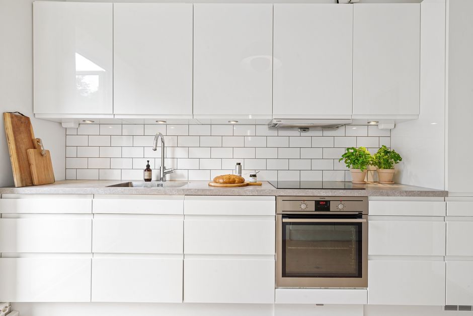 Lichte keuken met strakke lijnen en open rekken.